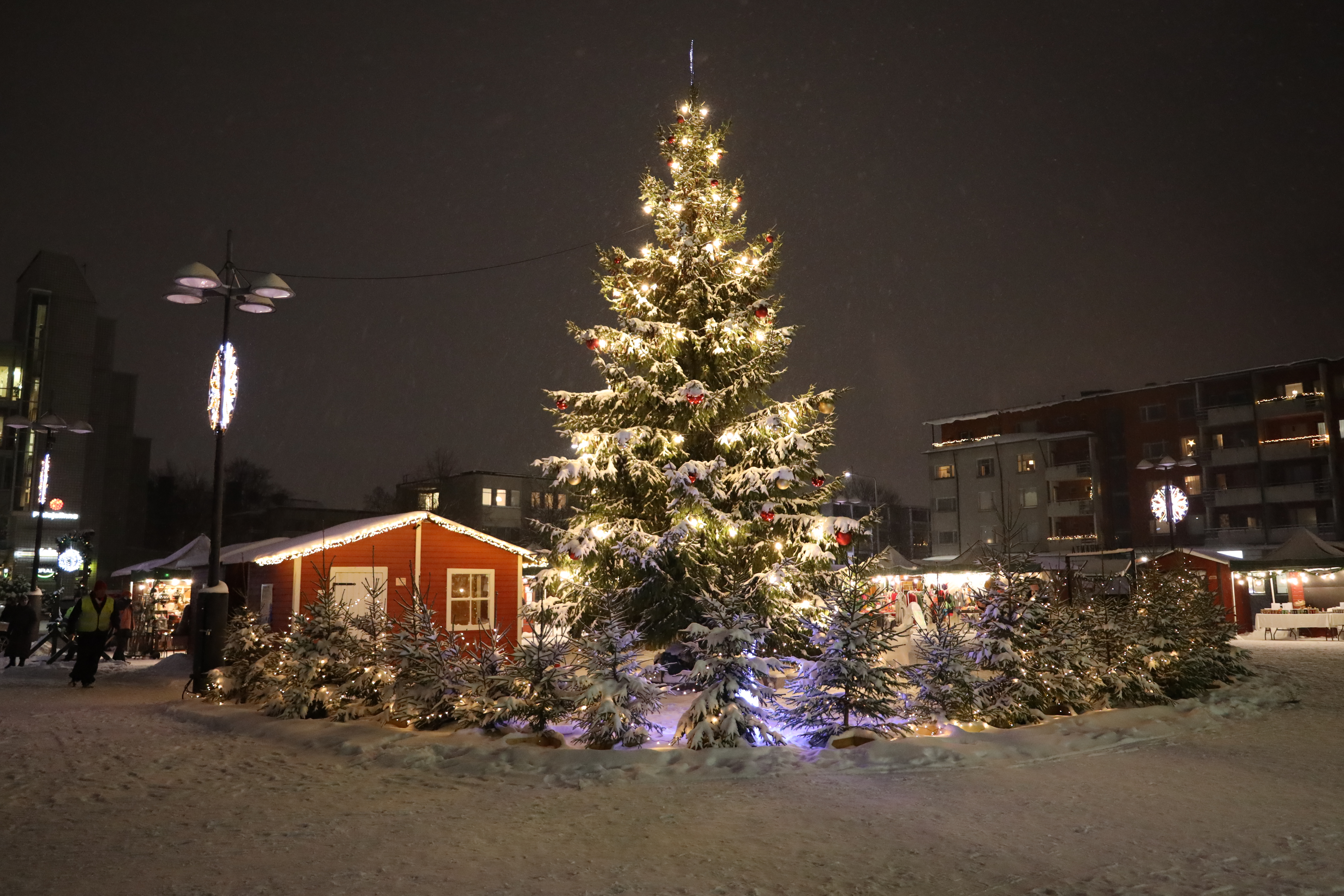 Joulukuusi joulutorilla hämärässä.